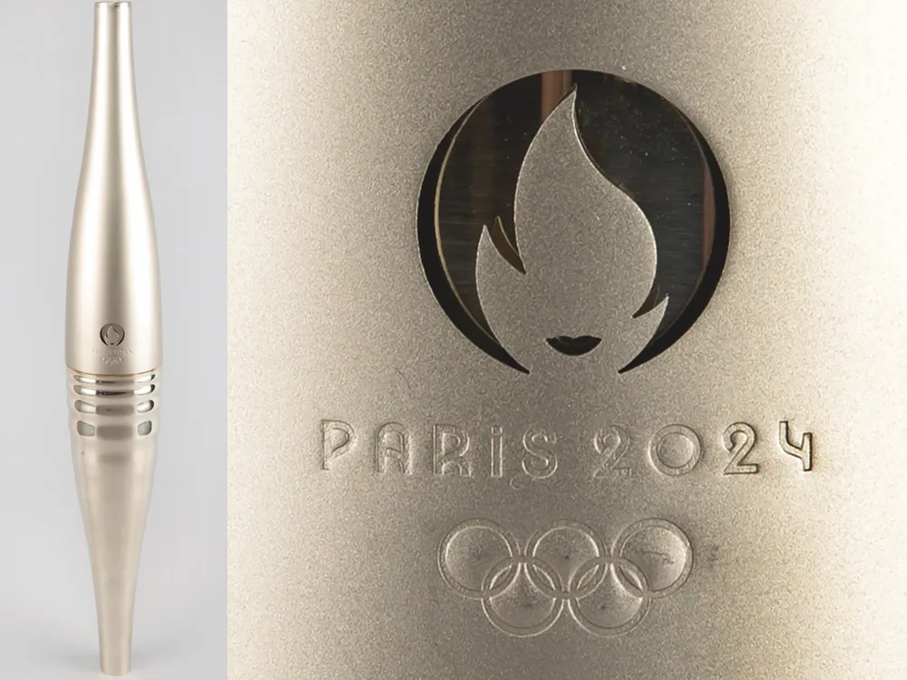 A long slender metal tube next to a close-up show of the Paris 2024 Olympics logo