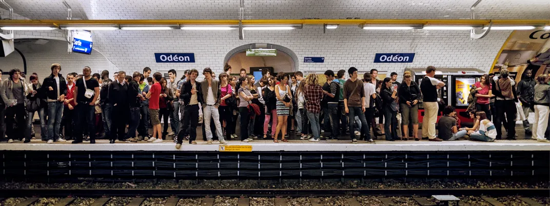 Travelers fill a train platform