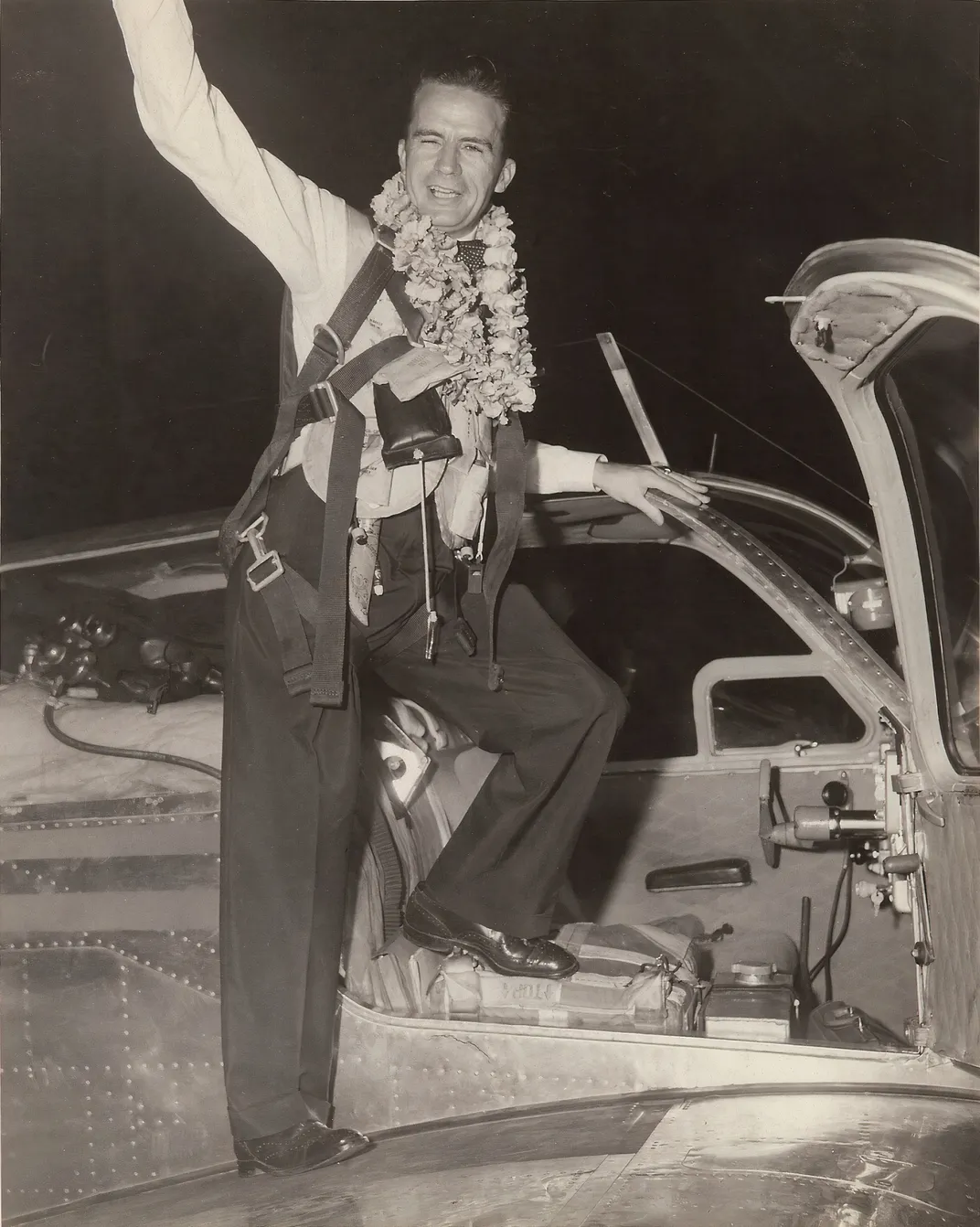 a man waves while exiting an airplane