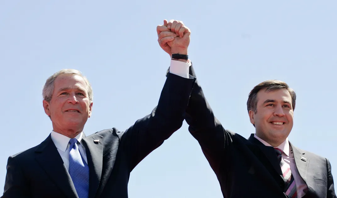 U.S. President George W. Bush (left) and Georgian President Mikheil Saakashvili (right) hold hands in Freedom Square in the Georgian capital Tbilisi on May 10, 2005.