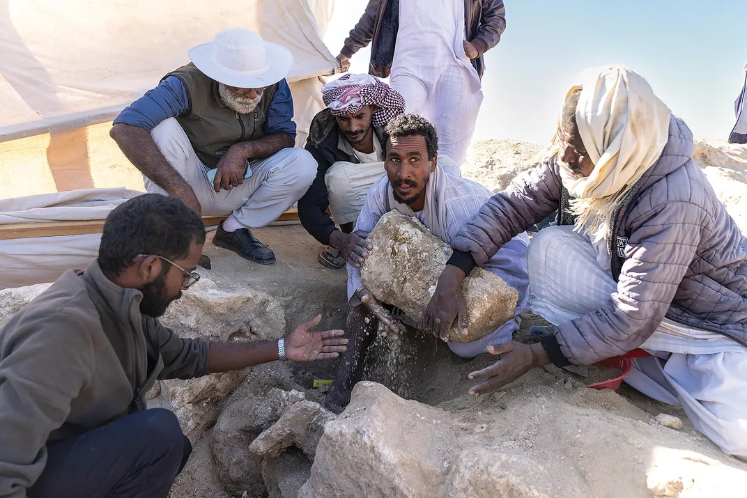 Workers recover the head of a statue