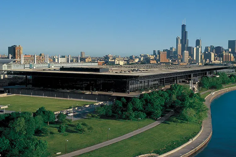 Large square building with a city skyline in the background